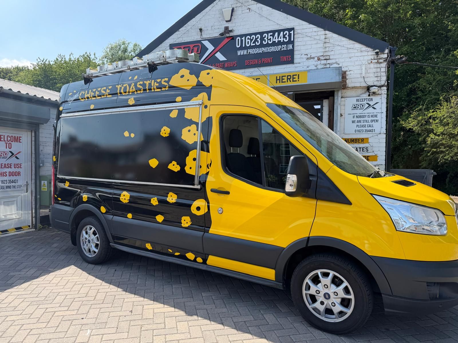 Yellow and black Cheese Toasties van wrap outside the Pro Graphix unit