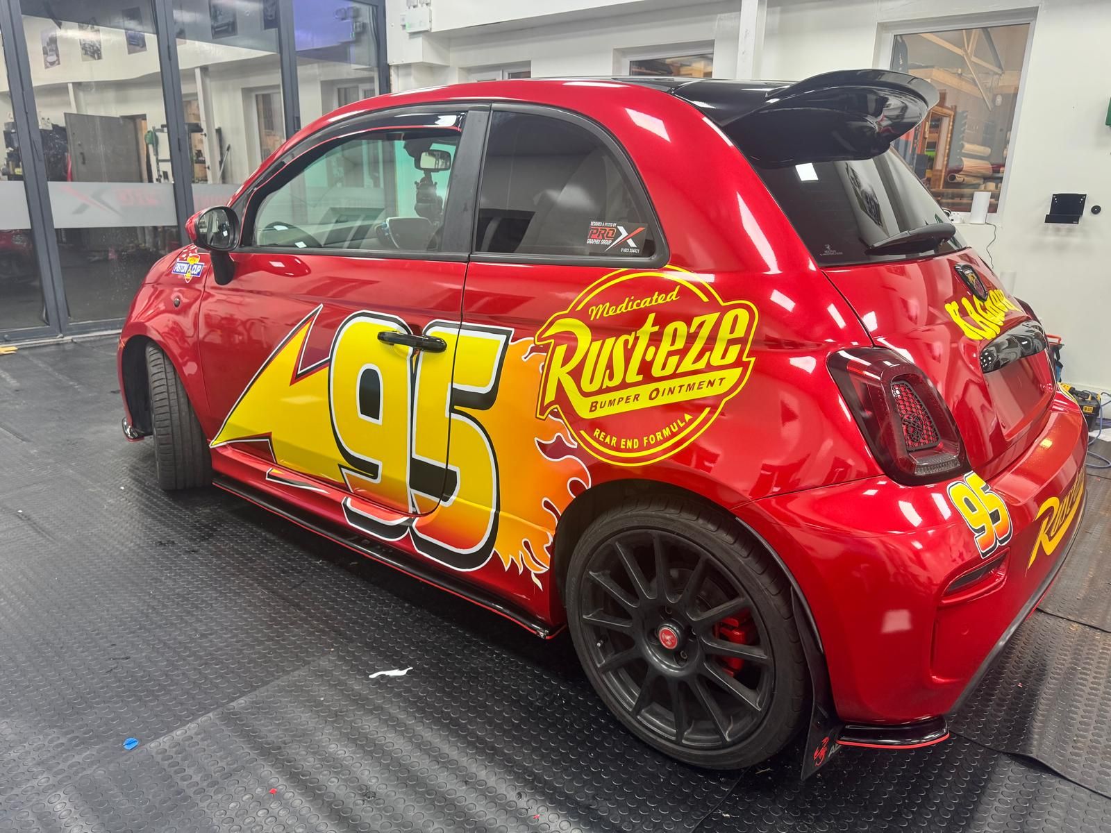 Red Fiat 500 wrapped with Rust-eze race graphics by Pro Graphix Group