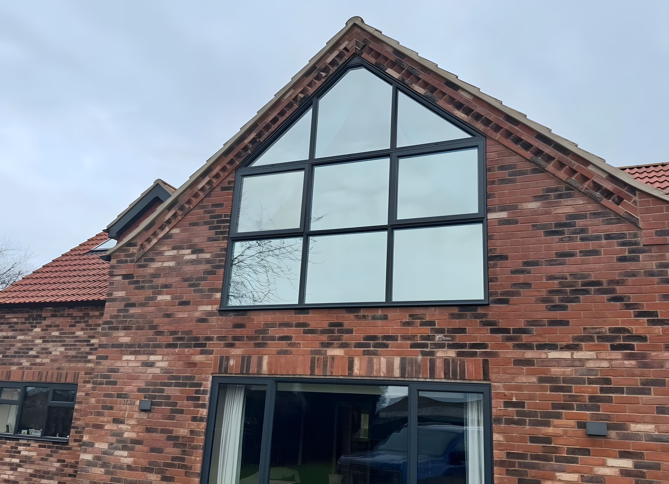 Solar film fitted to the large glazed gable of a brick house