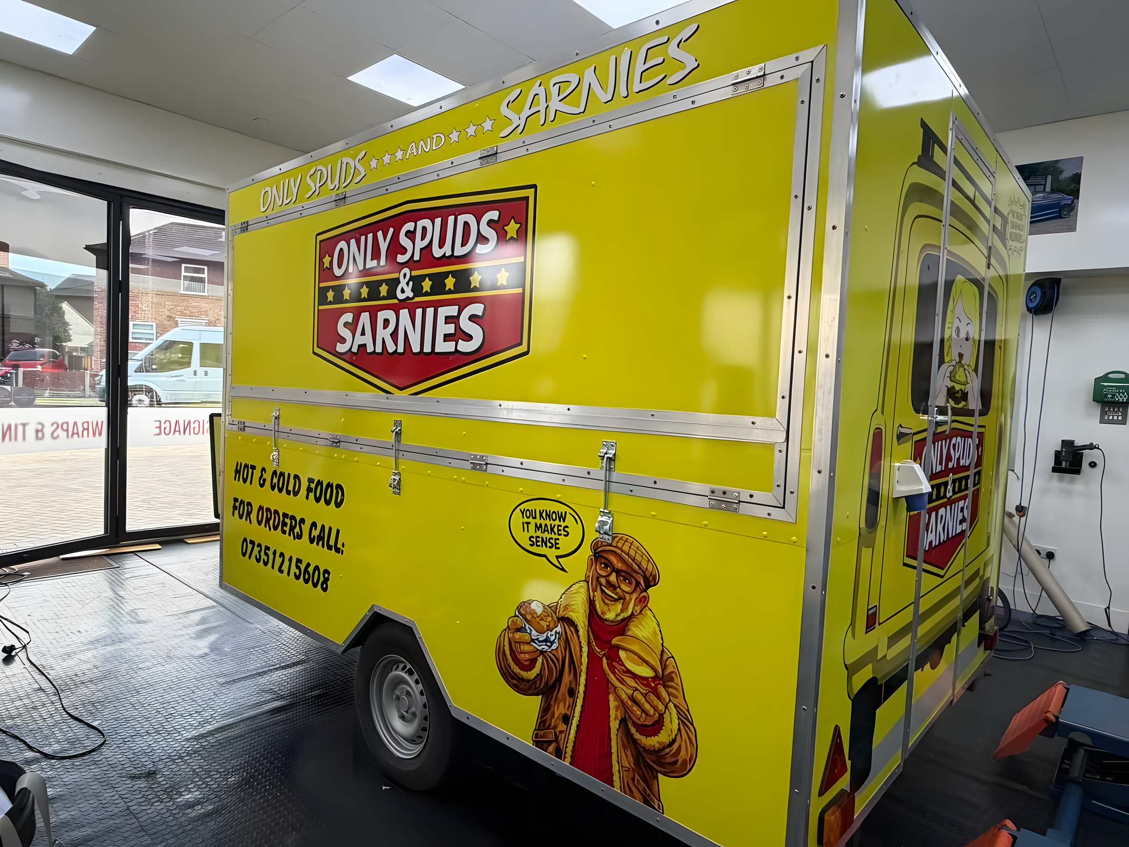 Only Spuds & Sarnies branding wrapped on the side of a catering trailer
