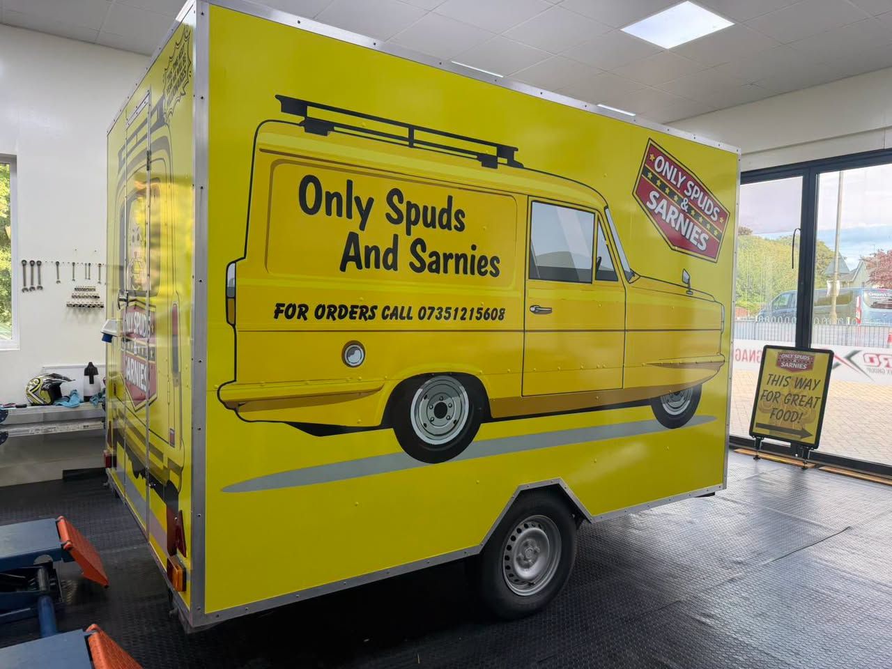 Yellow catering trailer wrapped as a classic three-wheeler van for Only Spuds & Sarnies